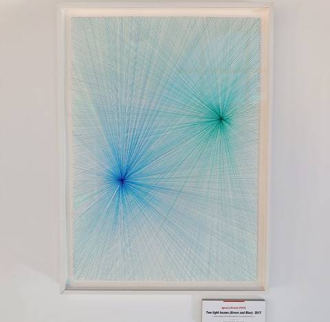 Una obra de arte abstracta que presenta líneas de color azul y verde dispuestas en un patrón radial.