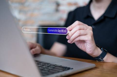 Una persona interactuando con una laptop mientras sostiene un texto que dice 'Generate by AI'.