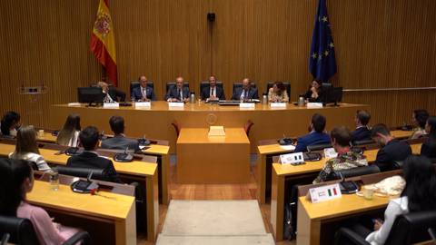 Una reunión formal en un salón de conferencias con autoridades y asistentes.