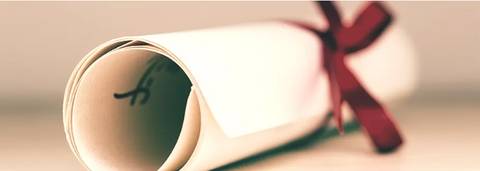 Un pergamino enrollado con una cinta roja atada en su parte superior.