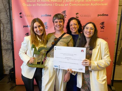 Las cuatro mujeres posan sonrientes sosteniendo un premio y un certificado en un evento de comunicación.