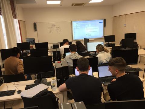 Un grupo de estudiantes trabajando en computadoras en un aula.