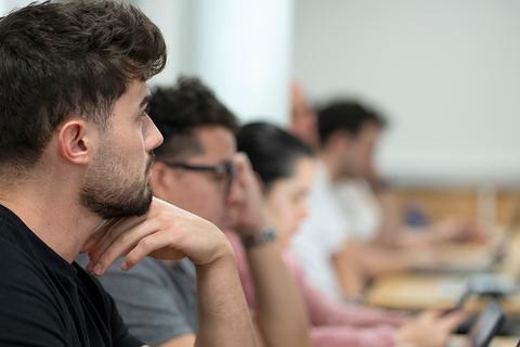 Un grupo de personas concentradas en un aula mientras utilizan computadoras portátiles.