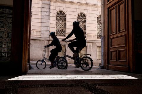 Siluetas de dos personas montando en bicicletas en un umbral de una puerta.
