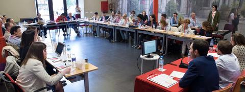 Una reunión en curso con varias personas en una mesa de conferencias.