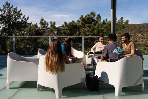 Varias personas conversando en un ambiente al aire libre con asientos modernos.