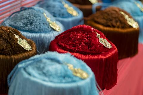 La imagen muestra una variedad de sombreros de colores con etiquetas visibles en un fondo uniforme.